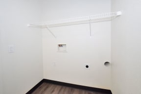 an empty room with a white wall and wood floor