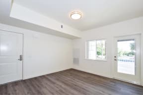 a bedroom with hardwood floors and white walls