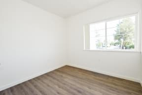 an empty room with a large window and white walls