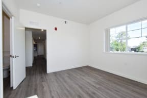 an empty room with a large window and white walls