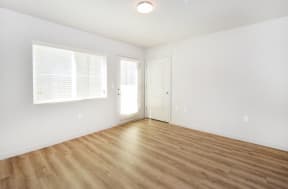 a bedroom with hardwood floors and white walls