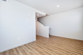 an empty living room with white walls and hardwood floors