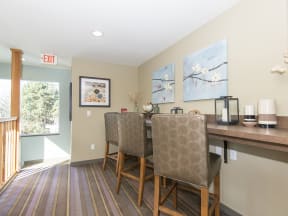 a dining area with two chairs and a bar with a counter and a window