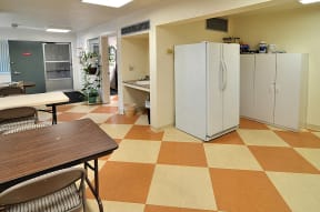 a kitchen with two refrigerators and a table and chairs