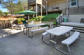 an outdoor patio with tables and chairs and an umbrella