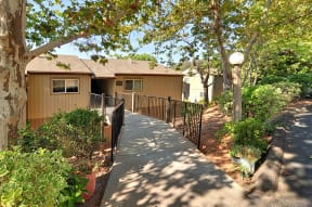 a pathway leading to a house with a fence