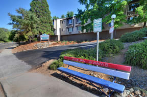 a red and blue park bench sitting on the side of a street