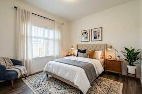 A bedroom with a large bed and a blue chair.