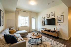 A living room with a couch, a coffee table, and a television.