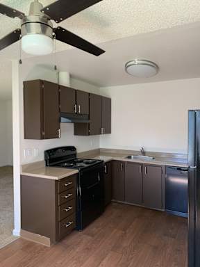 A kitchen with a black stove top oven and a black refrigerator.