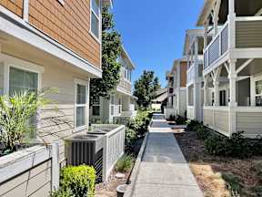 A row of houses with a sidewalk in between.