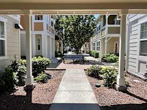 A walkway leads between two rows of white and beige houses.