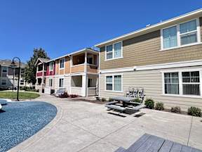 A sunny day at a residential complex with a pool and a picnic table.