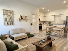 A modern living room with a wooden coffee table and a large window.