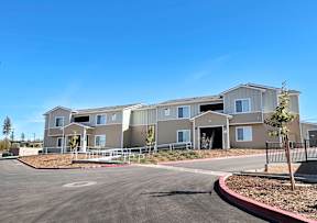 an exterior view of an apartment building with a parking lot