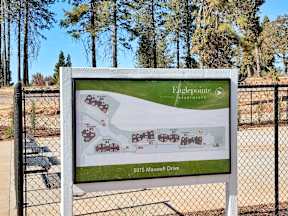 a sign with a map of a park and trees