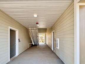 a hallway of a house with stairs and a door