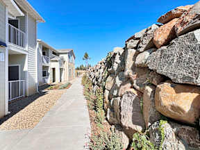 a large rock wall in front of a row of houses