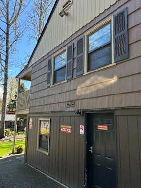 A building with a black door and a sign that says "OFFICE" on it.