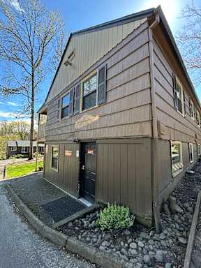 A building with a brown siding and a black door.