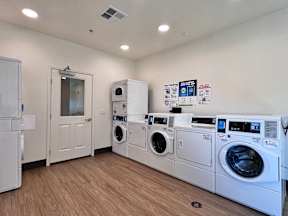 A laundry room with a stack of washers and dryers.