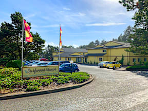 a view of the sidewalk market from the street with cars parked in front of it