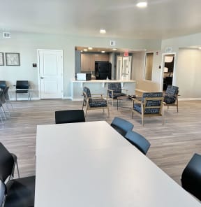 a room with a table and chairs and a kitchen
