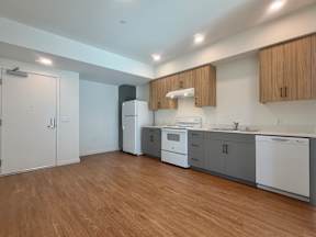 A kitchen with wooden floors and white appliances.