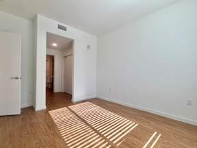 A room with a white door and a white wall with a light switch.