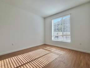 A room with a window and wooden flooring.