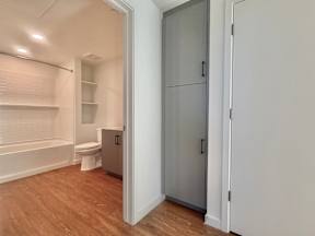 A white bathroom with a toilet, sink, and a large closet.