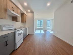 A kitchen with white appliances and wooden cabinets.