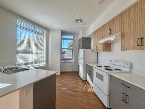 A modern kitchen with white appliances and wooden cabinets.