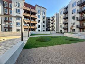 A modern apartment complex with a courtyard and landscaping.