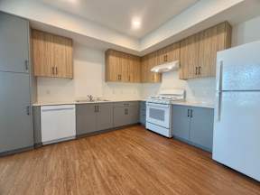 A kitchen with wooden floors and white appliances.