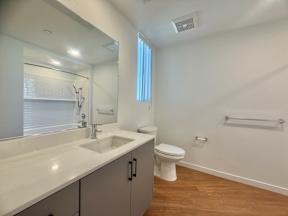 A white bathroom with a toilet, sink, and mirror.