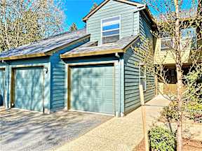 a blue garage with a blue house with two garage doors