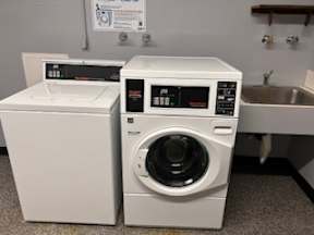 A white washing machine and dryer in a laundry room.