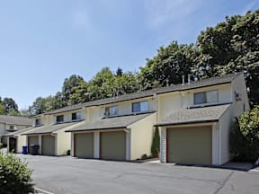 a row of yellow houses with a parking lot