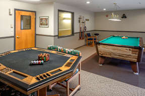 A pool table with a green cloth and a pool cue on it.