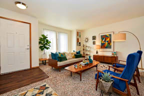A living room with a blue chair and a wooden bench.