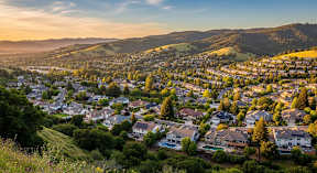 A sunset view of a residential neighborhood nestled in the hills.