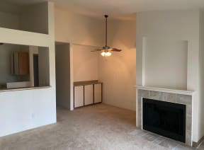 a living room with a fireplace and a ceiling fan