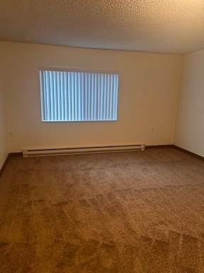 A small window with white blinds in a room.