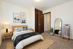 A bedroom with a large bed and a mirror on the wall.
