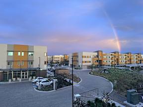a rainbow in the sky over an apartment complex