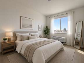 A well-lit bedroom with a large bed and a view of the outdoors through the window.
