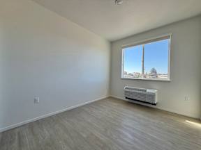 A room with a window and a wall-mounted air conditioner.