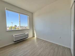 A room with a window and a wall-mounted air conditioner.