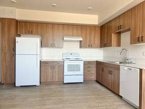 A modern kitchen with wooden cabinets and white appliances.